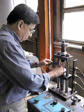 Dr. Deepak Kapur operating a Corbin Hydro-Press in Building 1609